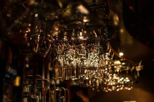 Wine glasses hanging above a bar counter