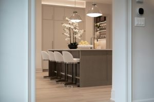 A kitchen island with wine storage in the background