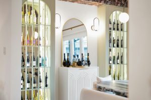 Illuminated wine display niches in a bright bar area
