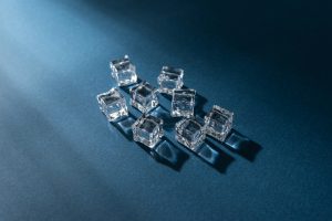 Clear ice cubes arranged on a deep blue surface