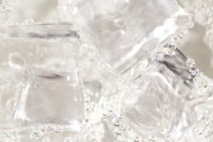 Ice cubes and rising bubbles in a chilled glass