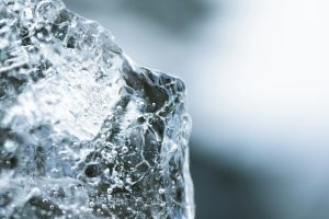 A single chunk of clear ice against a soft background