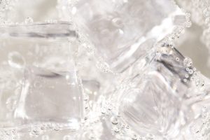 Clear ice cubes surrounded by carbonation bubbles