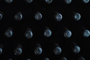 A pattern of wine bottle tops in low light