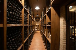 A wine cellar corridor lined with bottle racks