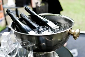 Dark bottles chilling in a steel ice bowl